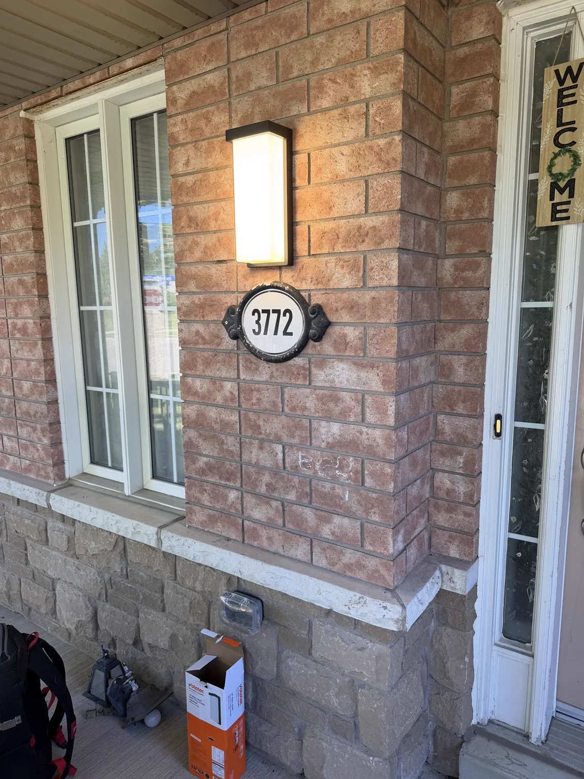 Outdoor wall lantern installation on a brick home